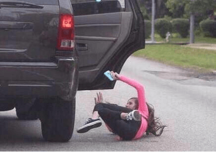 Girls falls out of vehicle because she's distracted using phone — fail moment