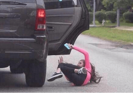 Girls falls out of vehicle because she's distracted using phone — fail moment