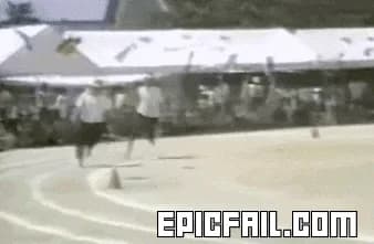 Two runners in matching white shirts race down a stadium track in perfectly synced strides.